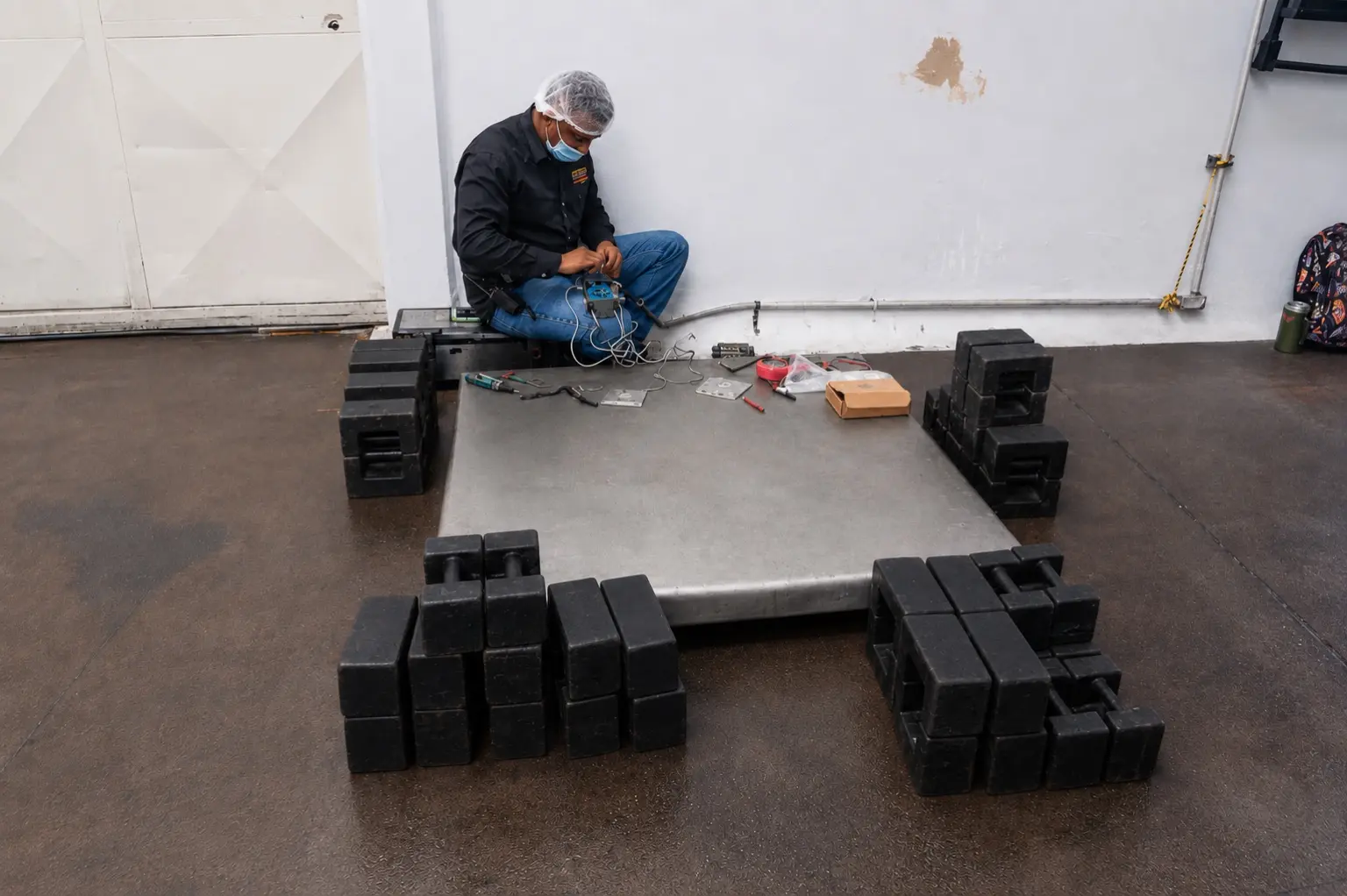 Técnico de Balanzas Valencia preparando una plataforma con masas de referencia